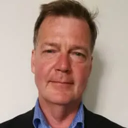 Profile image of John Kears, Co-owner of Nextware Group with blue shirt and black jacket.
