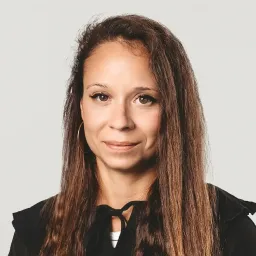 Portrait of Magda, a UX/UI designer with long, straight hair, wearing a black hoodie with a tied collar.