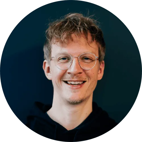 In the photo, a smiling Max Rieger in glasses.