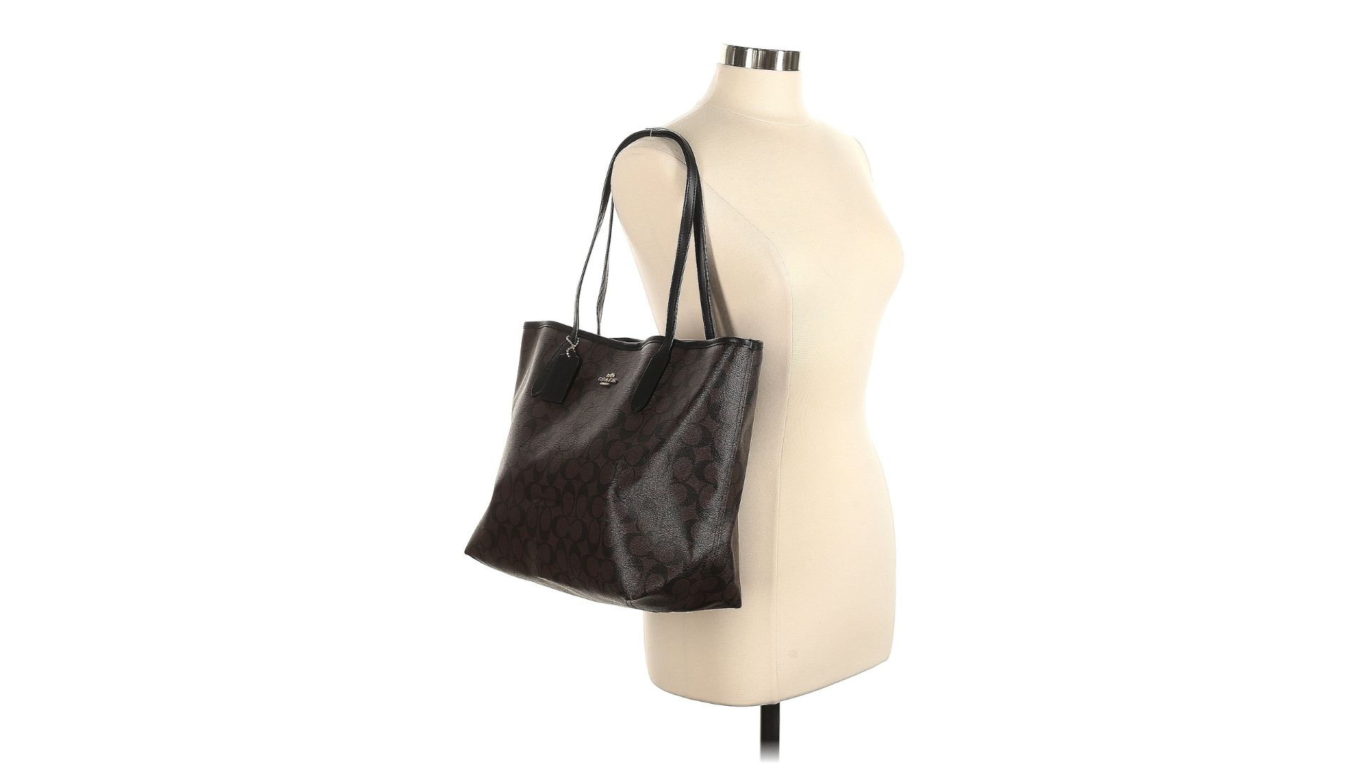 A large brown tote bag hanging from the straps on a torso-only mannequin.