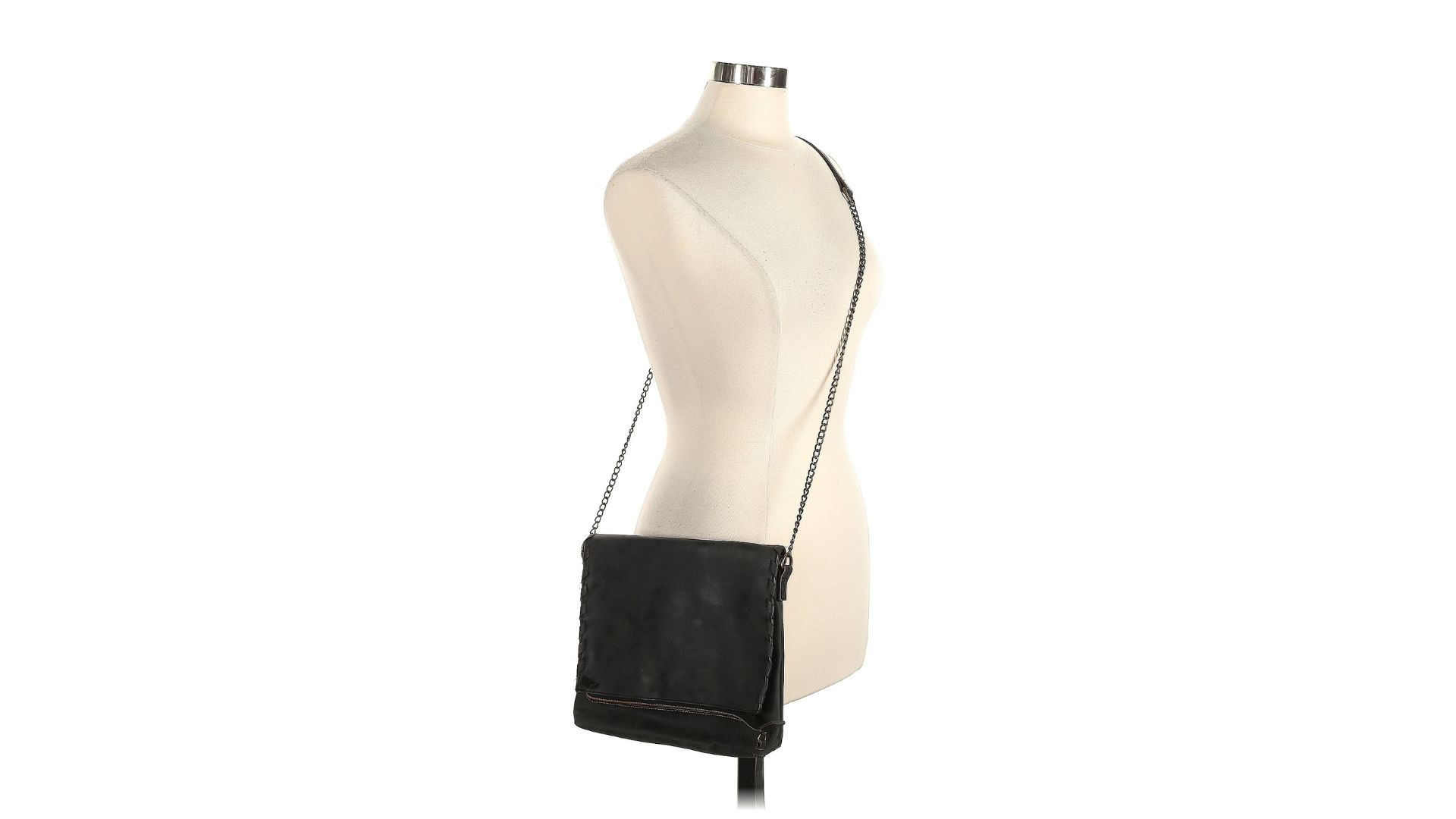 A black messenger bag hanging from the strap on a torso-only mannequin.