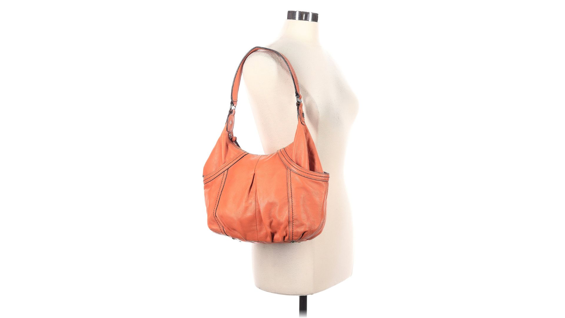 An orange shoulder bag hanging from the strap on a torso-only mannequin.
