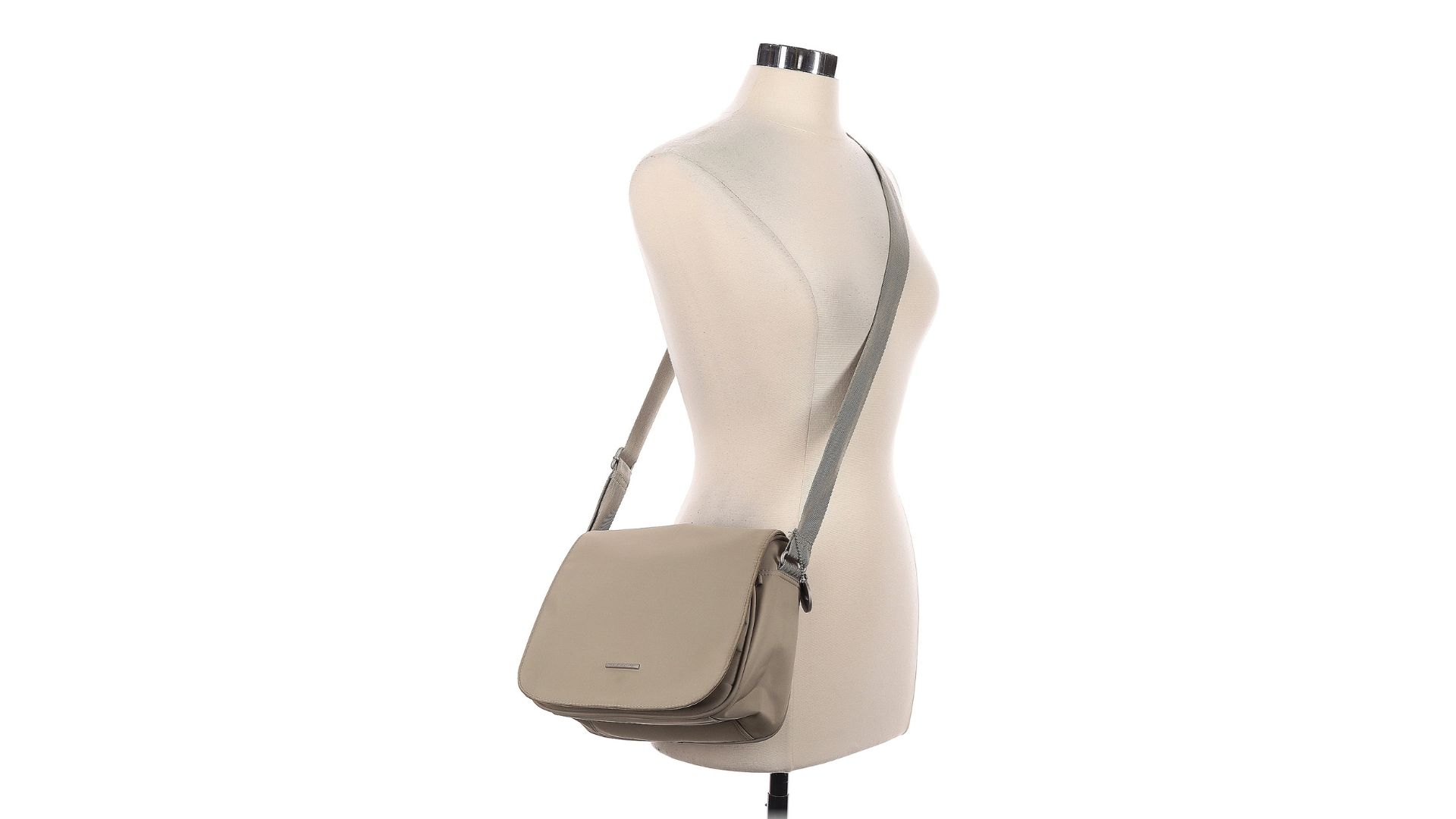 A beige crossbody bag hanging from the strap on a torso-only mannequin.