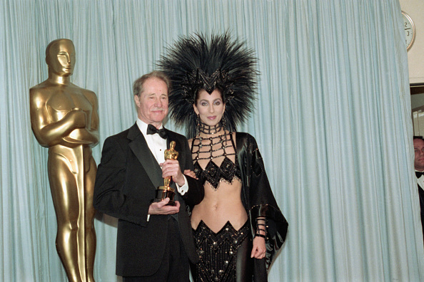 Cher in the 1986 Oscar's red carpet with a bejeweled bodysuit, together with a large, feathered top hat.