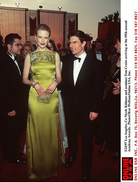 Nicole Kidman in the 1997 Oscars wearing a green embroidered silk dress next to Tom Cruise.