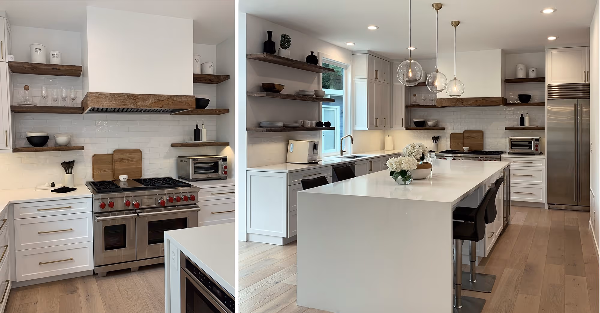 A modern kitchen featuring a blend of white cabinetry and light wood open shelving. The left side shows a stainless steel double oven with red knobs, a range hood with a wooden trim, and a white subway tile backsplash. Open wooden shelves hold decorative items and kitchen essentials. The right side of the image showcases a spacious kitchen island with a white countertop, equipped with bar stools, a sink, and pendant lights above. The kitchen also includes a large stainless steel refrigerator, a toaster oven, and additional counter space with under-cabinet lighting. The flooring is light wood, enhancing the bright and airy feel of the space.
