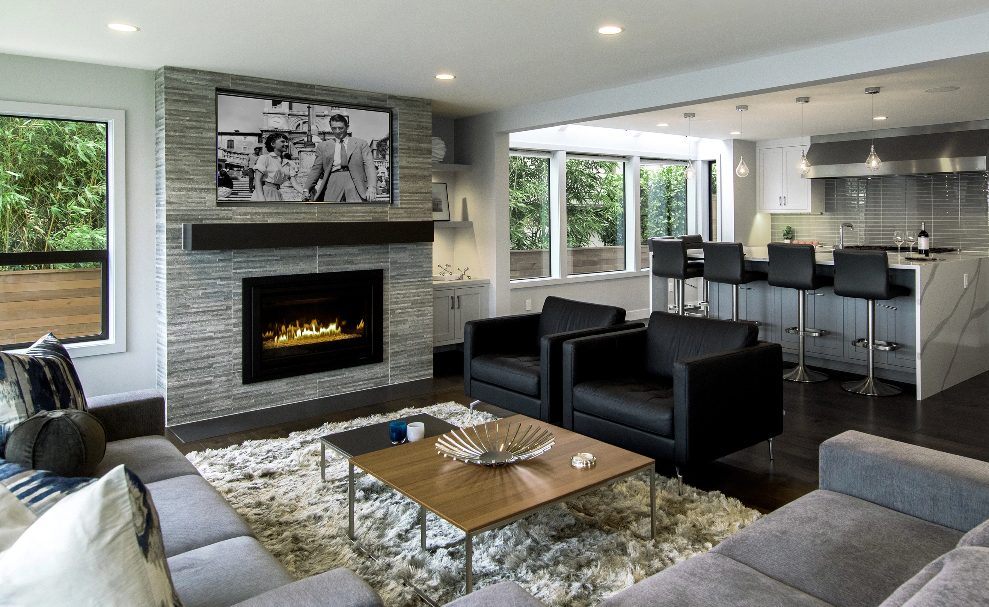 Room with blue walls featuring a white tree with orange leaves decal, gray sliding barn doors, modern wood table with colorful chairs, and a floor lamp.