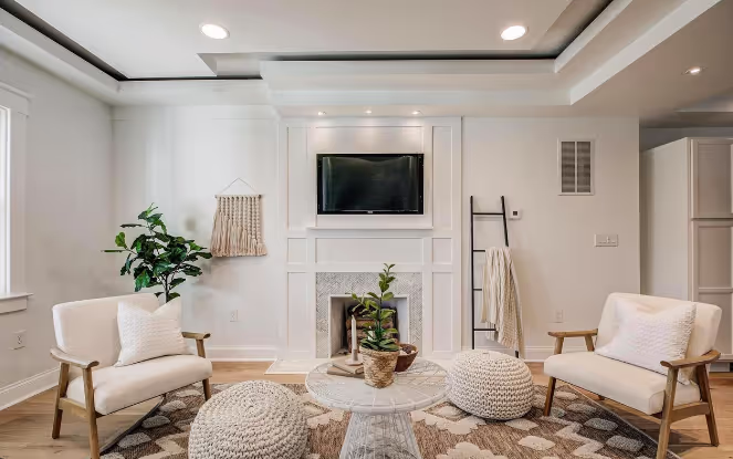 Renovated living room area featuring new hardwood floors, recessed lighting, and a modern fireplace with stylish furnishings in an open, inviting layout