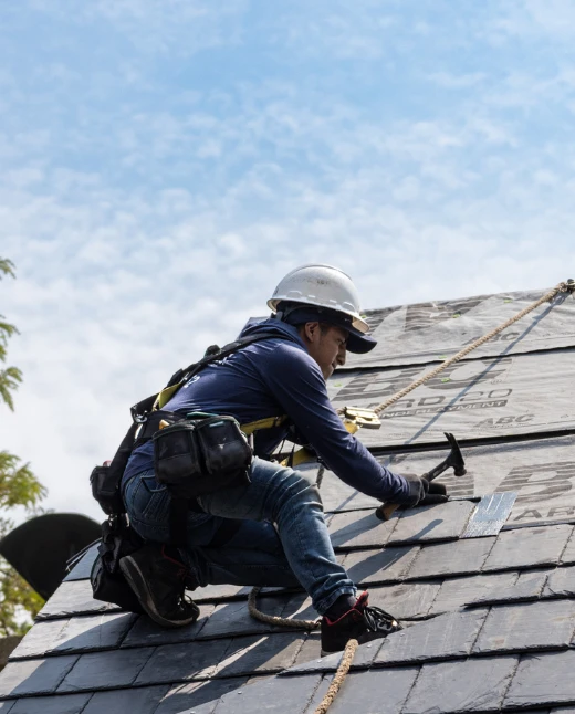 Roofer installing slate.