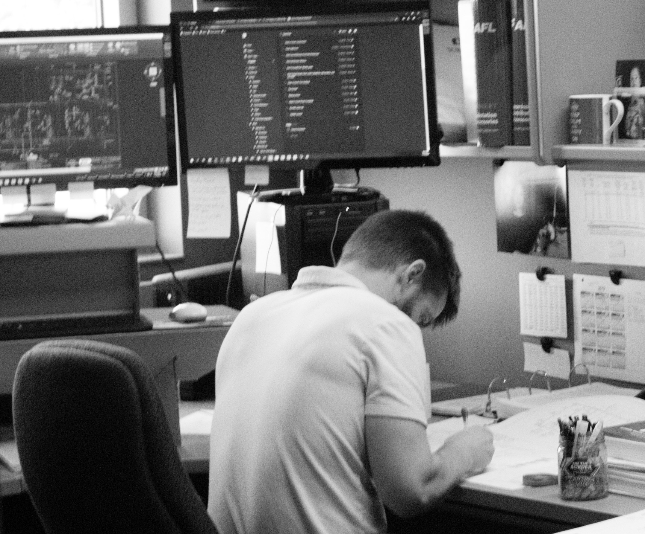An engineer works meticulously on a project at his office desk