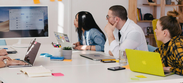 Two professionals sitting quietly in a meeting – hesitant to speak or struggling to be heard