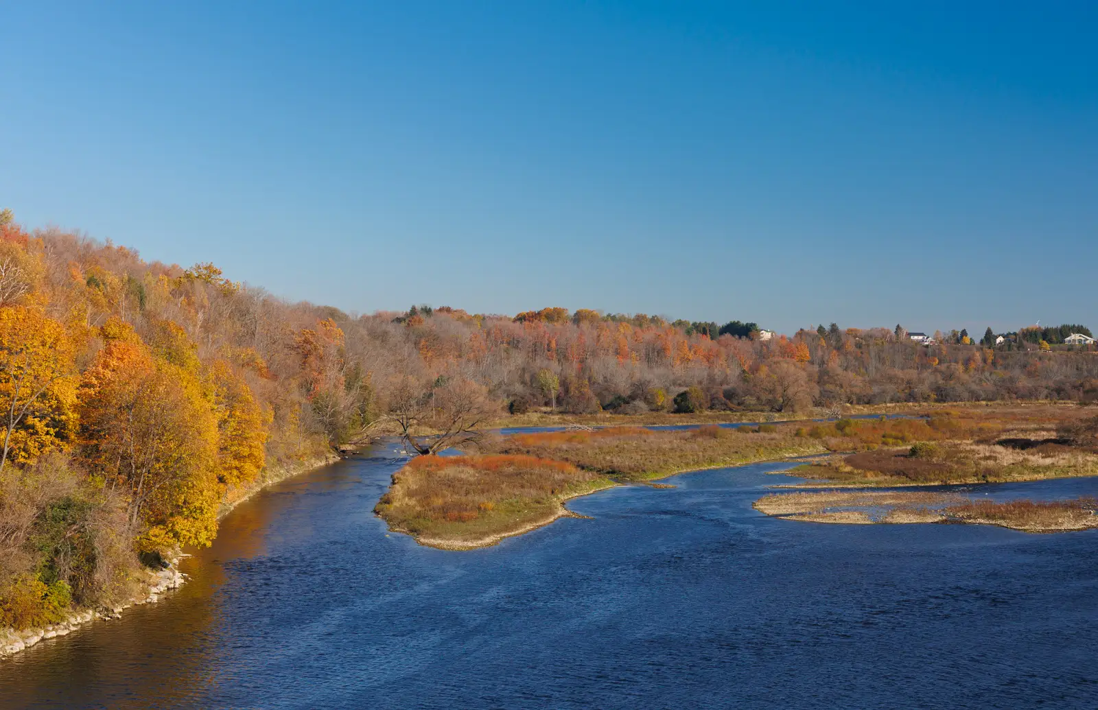 The Maitland River winding through autumn trees, viewed from the Menesetung Bridge.