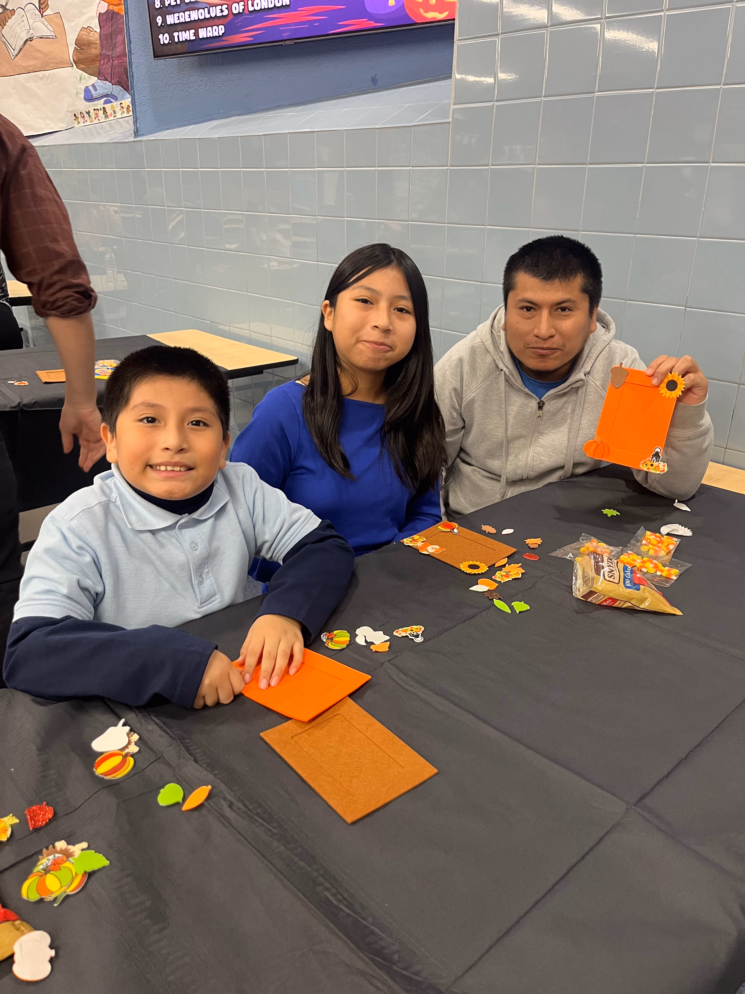 Students and family member making fall crafts at school event