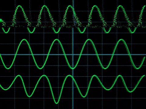 Green waveforms on an oscilloscope: a jagged noisy trace above two steady sine waves, illustrating signal versus noise. 