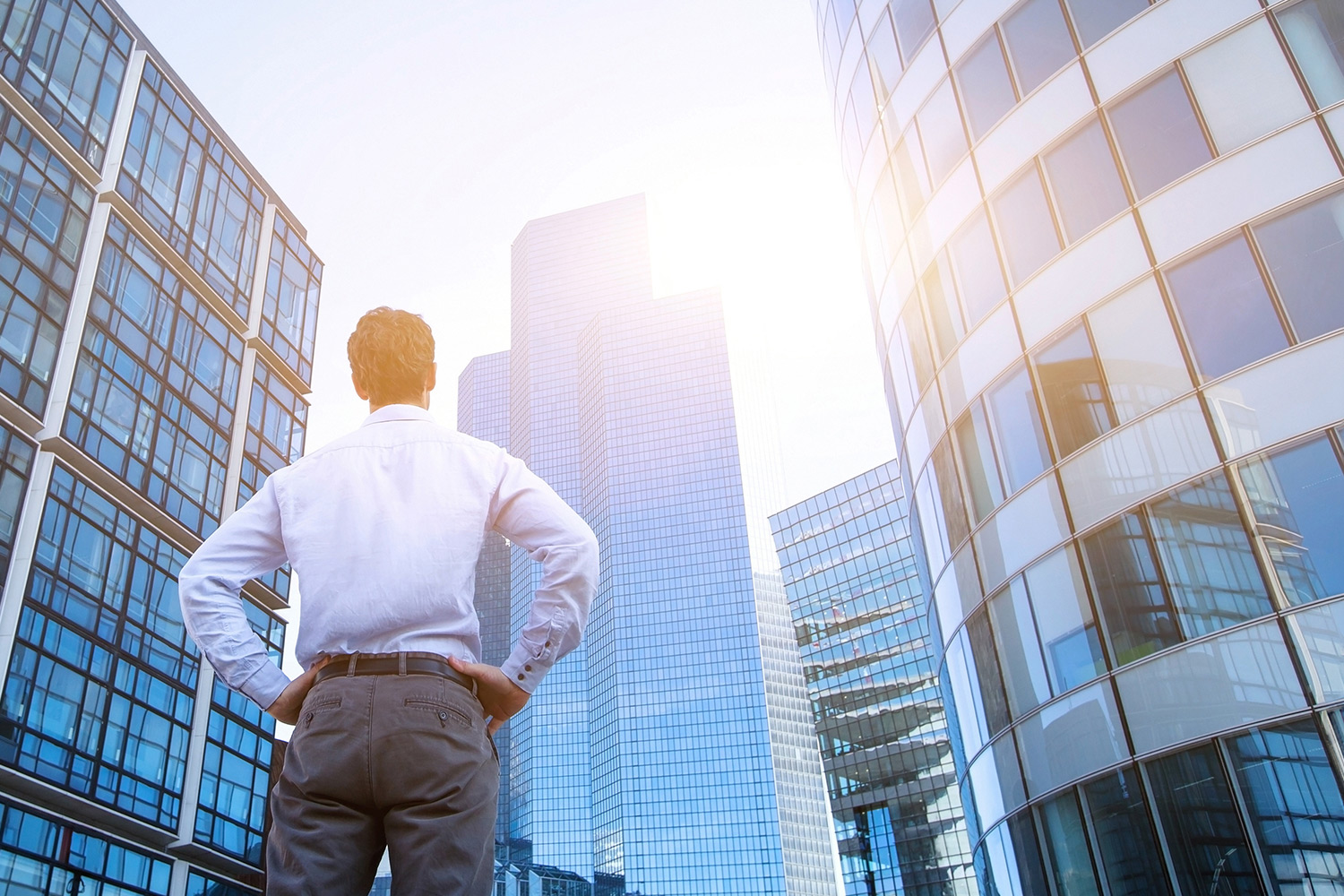 man admiring morning sun on city buildings