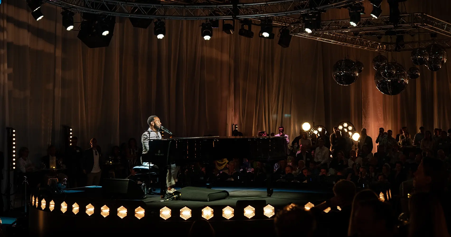 Singer John Legend performs on stage at a live event supported by Insert Productions