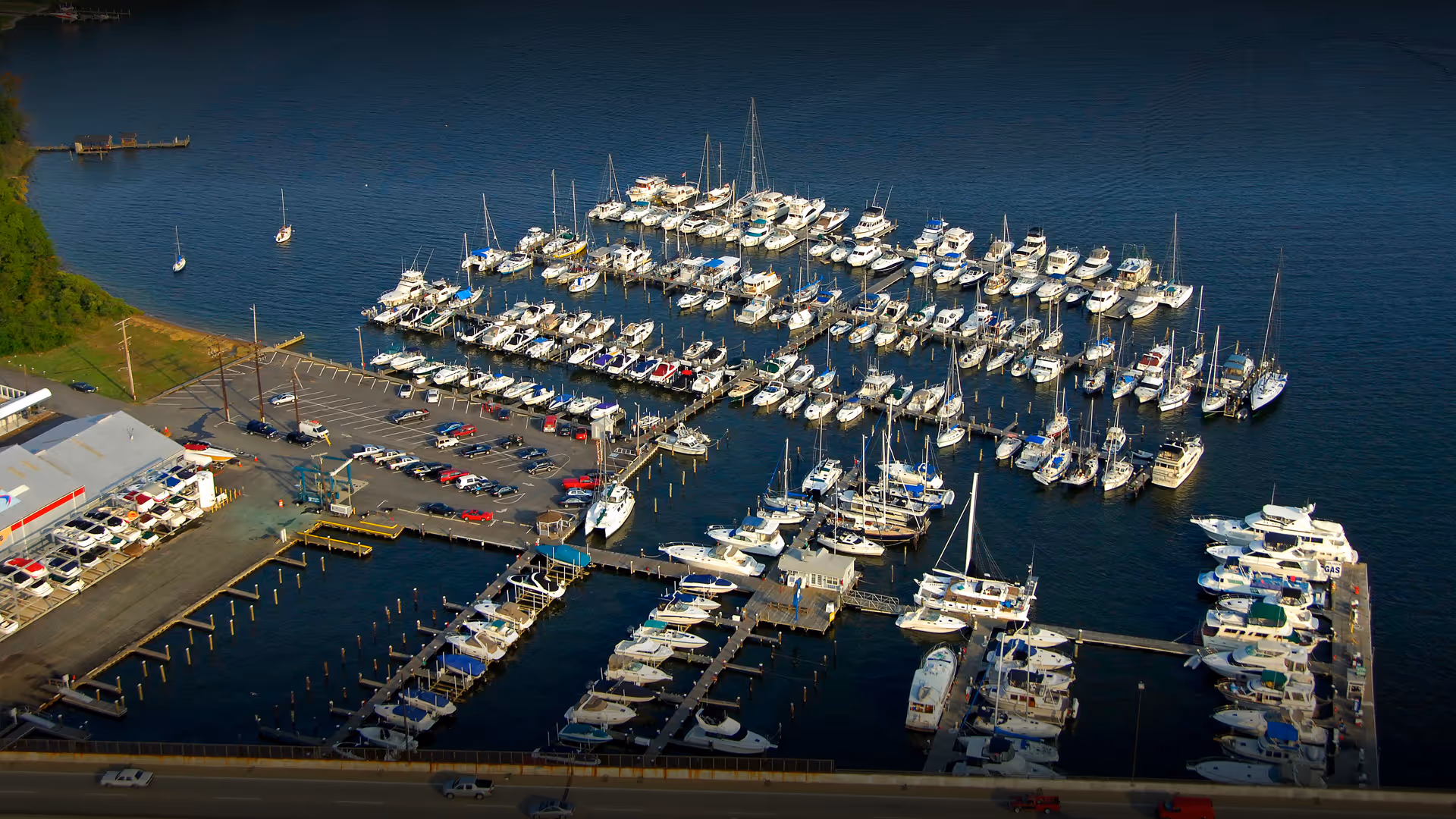 Aerial drone image of Liberty Marina located at the foot of the South River Bridge, showcasing boat slips, land storage, and the marina’s prime waterfront location.