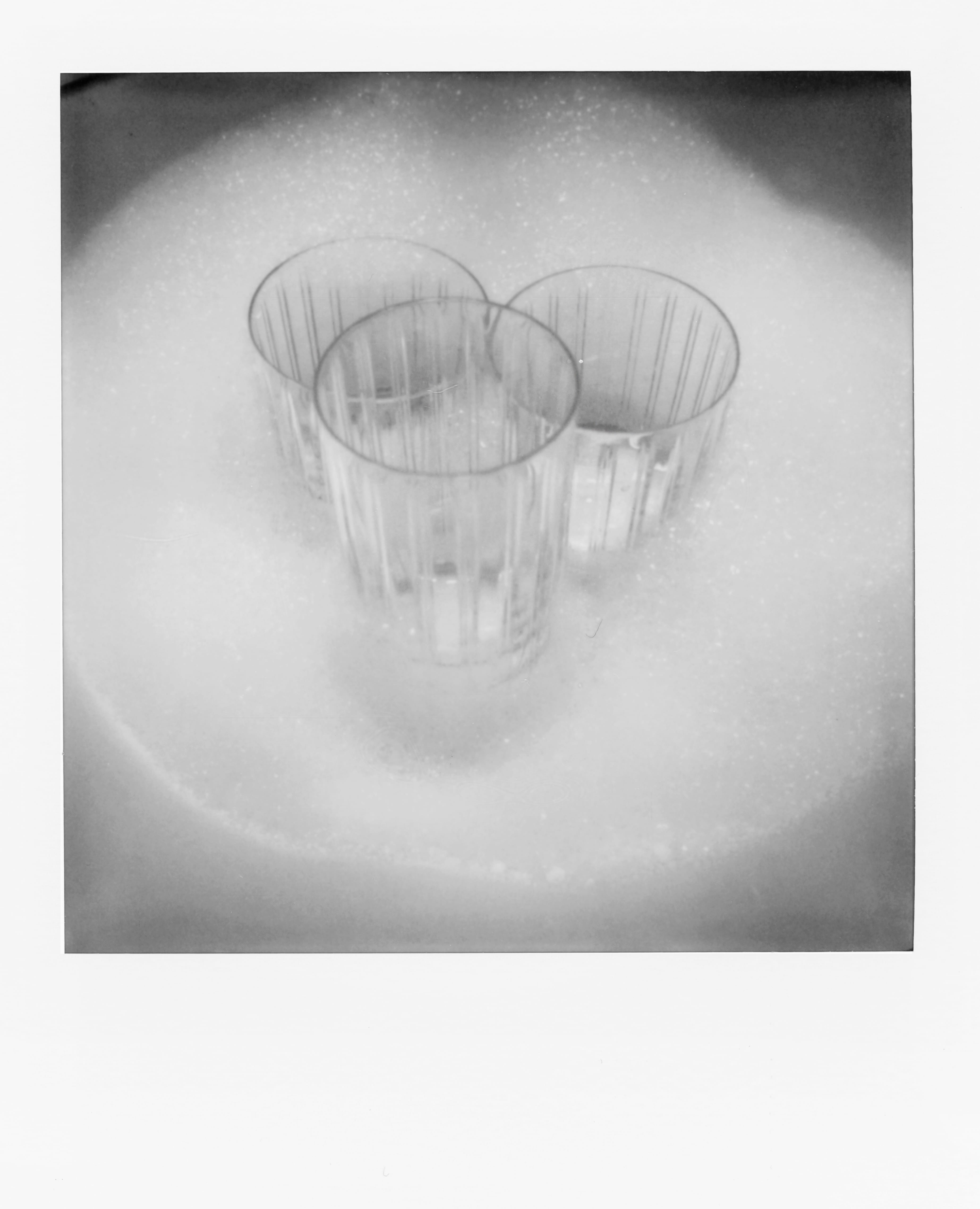 Three clear plastic cups partially submerged in white foamy bubbles.