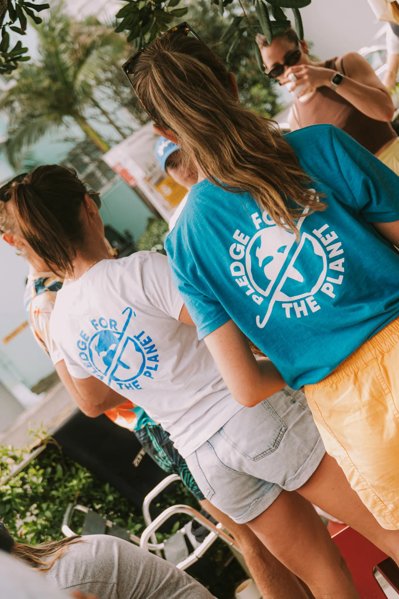 Two people wearing Pledge for the Planet t-shirts