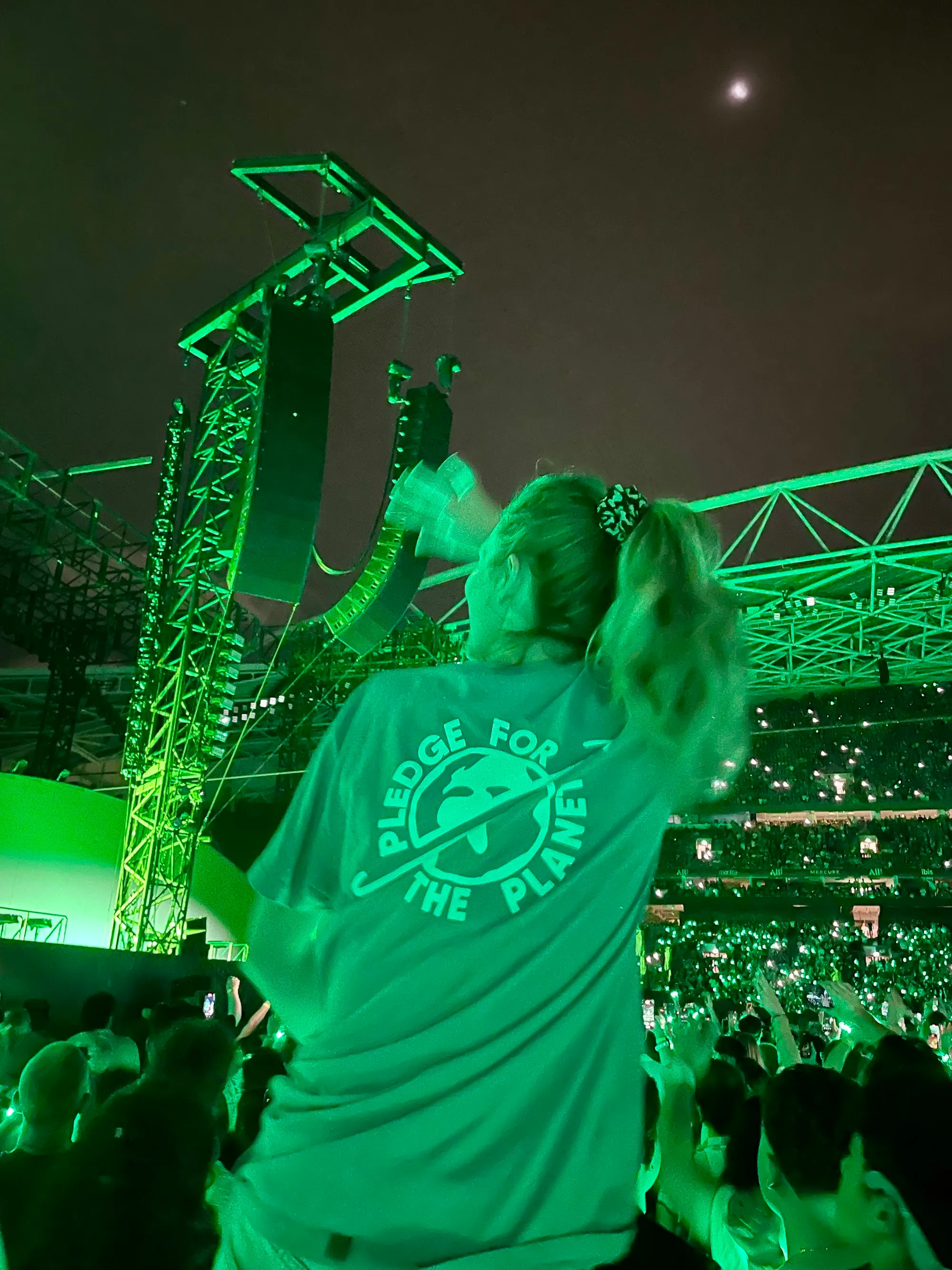 A fan in a Pledge t-shirt in the crowd at a Coldplay show