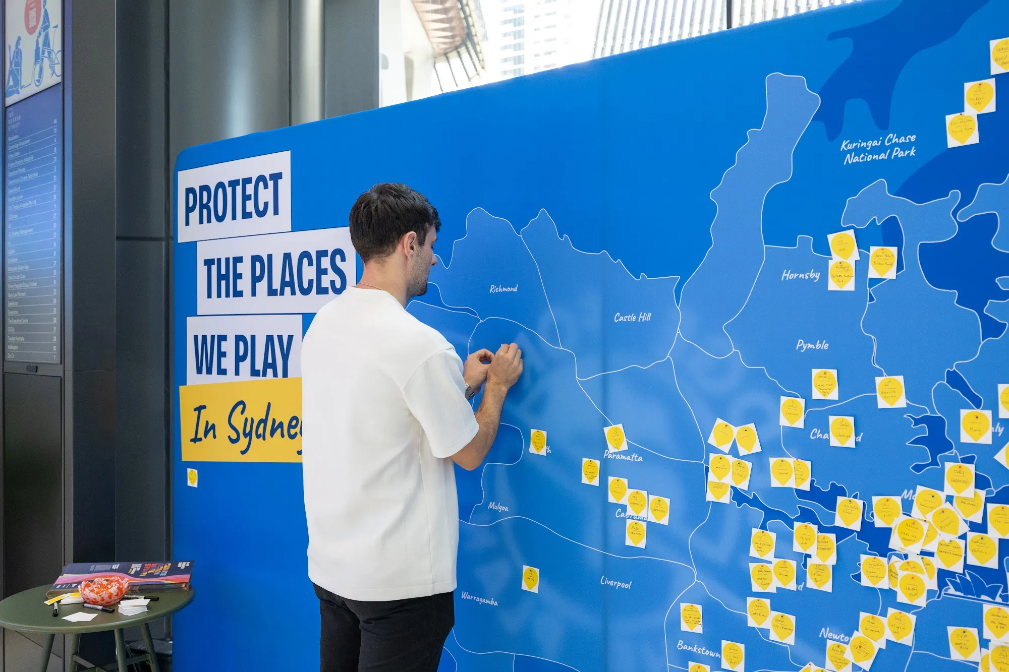 A JLL staff member adding a pledge to the Sydney map wall in the 180 George Street lobby