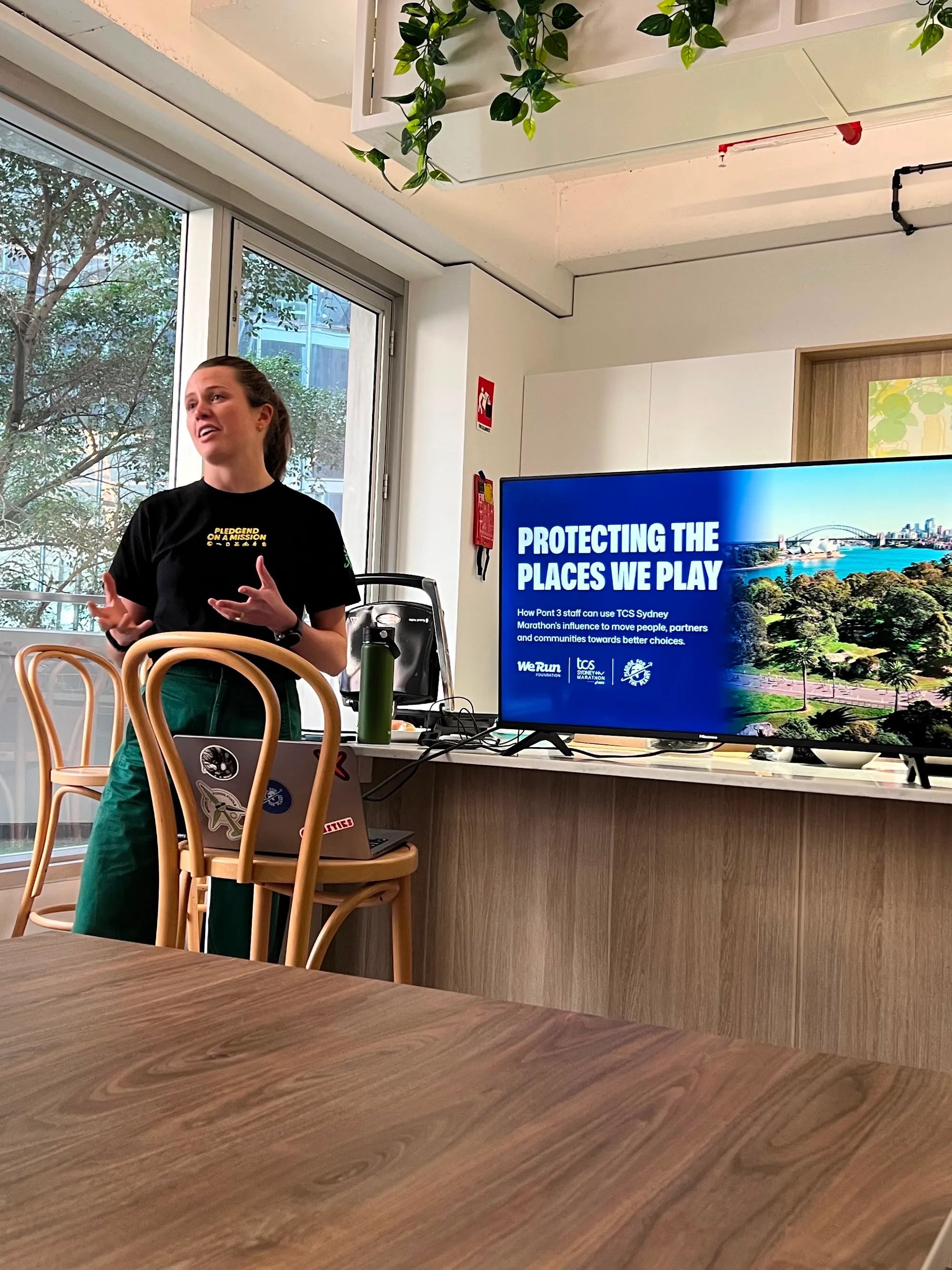 A Pledge facilitator presenting beside a screen reading Protecting the Places We Play in an office breakout space