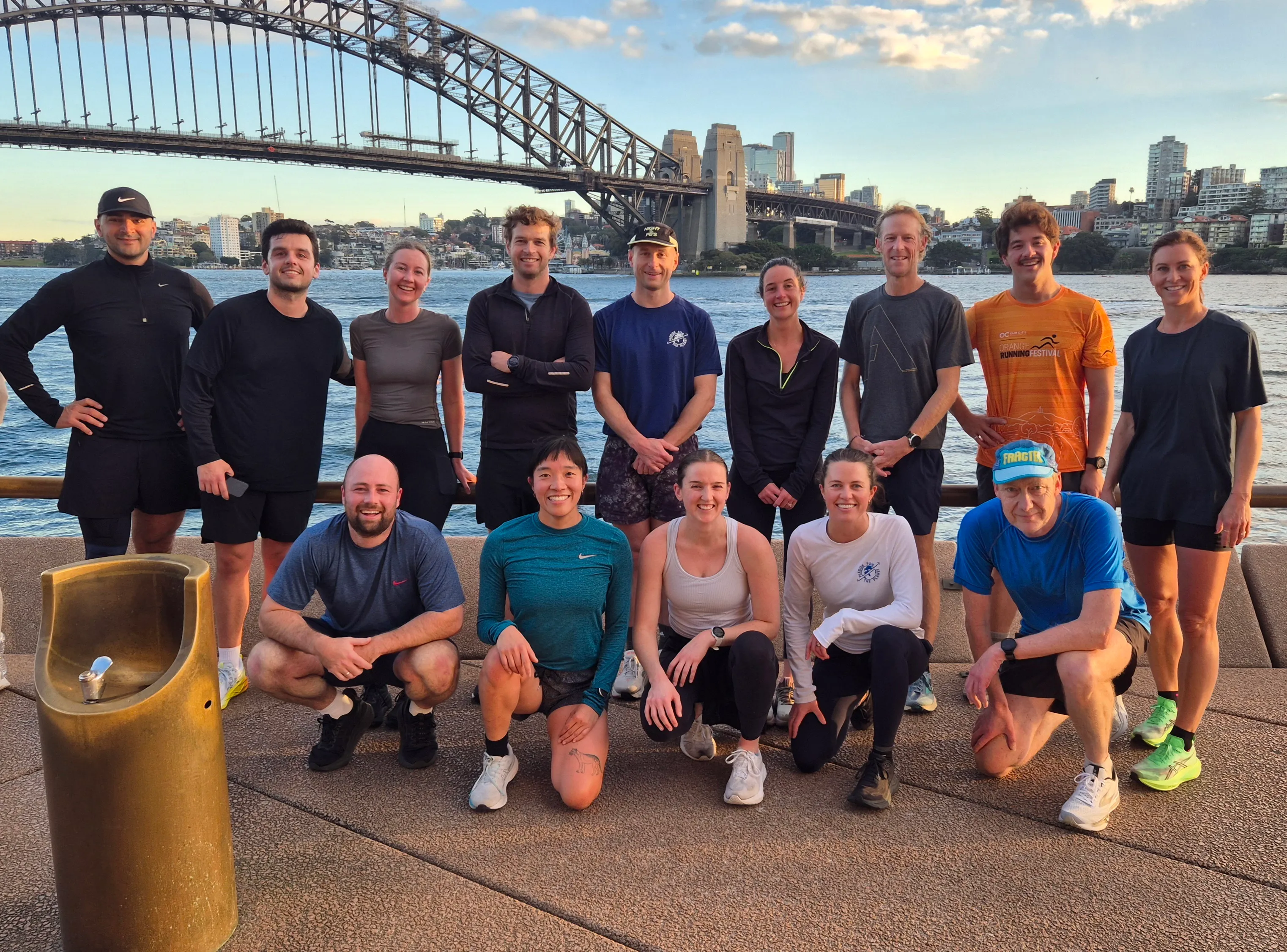 Running group posing in front of the Sydney Harbour Bridge at sunrise