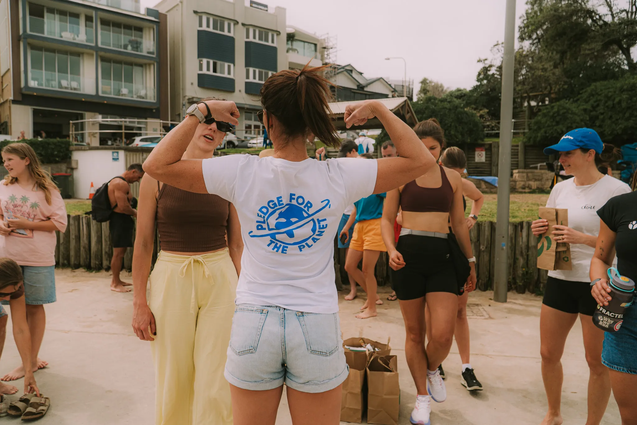 Volunteer in a Pledge for the Planet t-shirt at a beachside community gathering
