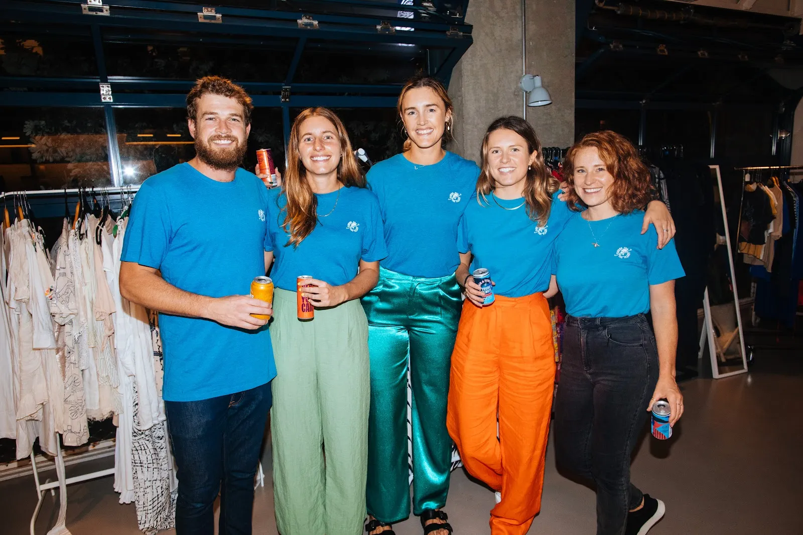 Five of the Pledge for the Planet team together in blue branded tees at a community clothes swap