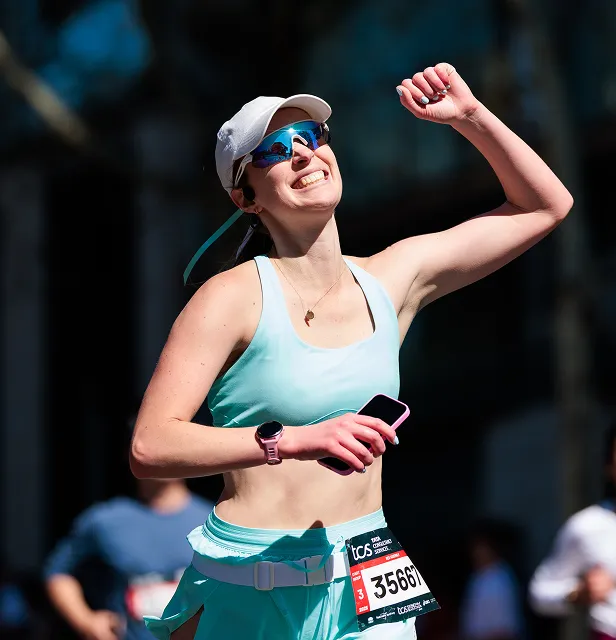 A smiling runner in sunglasses and a cap during the TCS Sydney Marathon