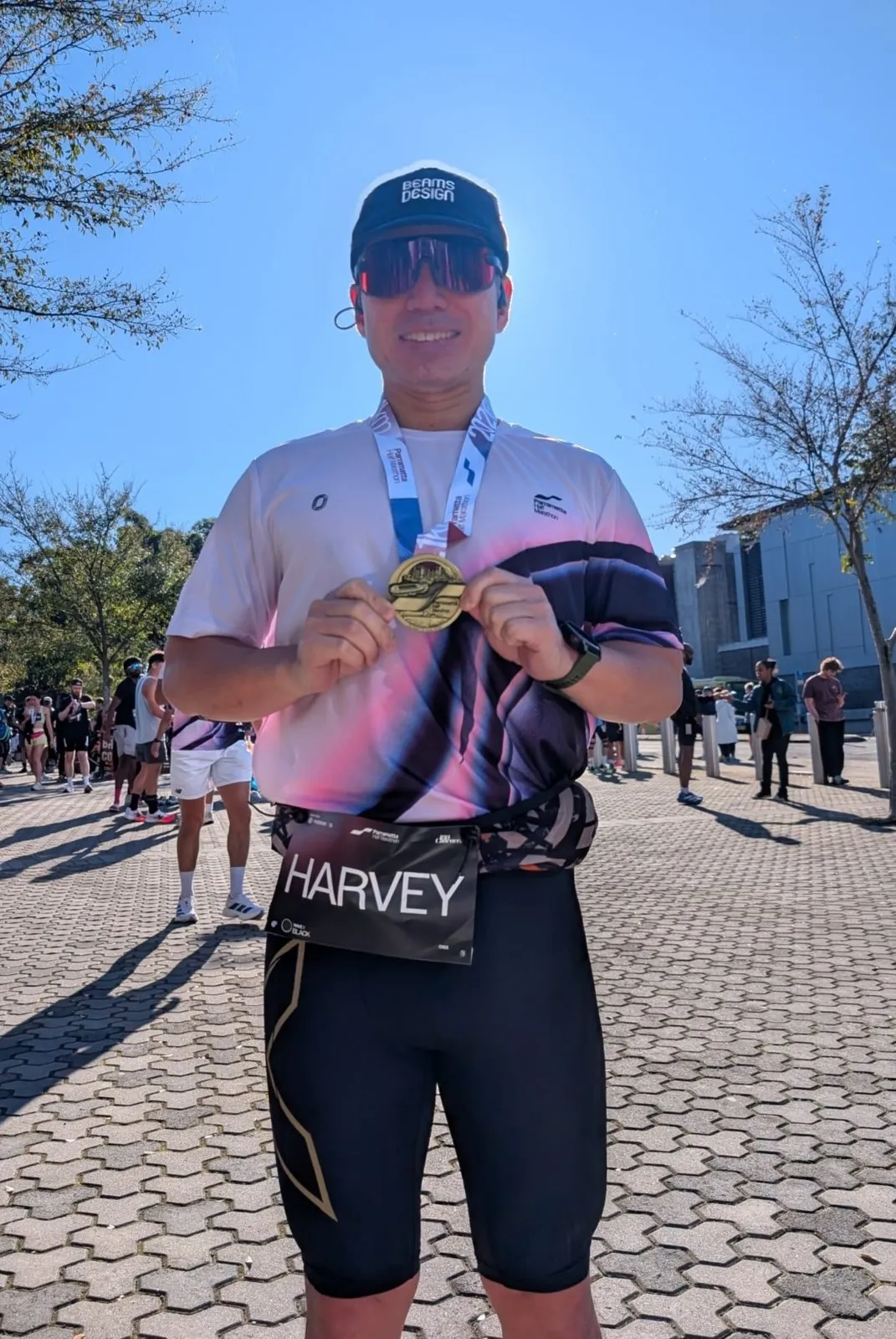 Harvey Ng holding up his TCS Sydney Marathon medal
