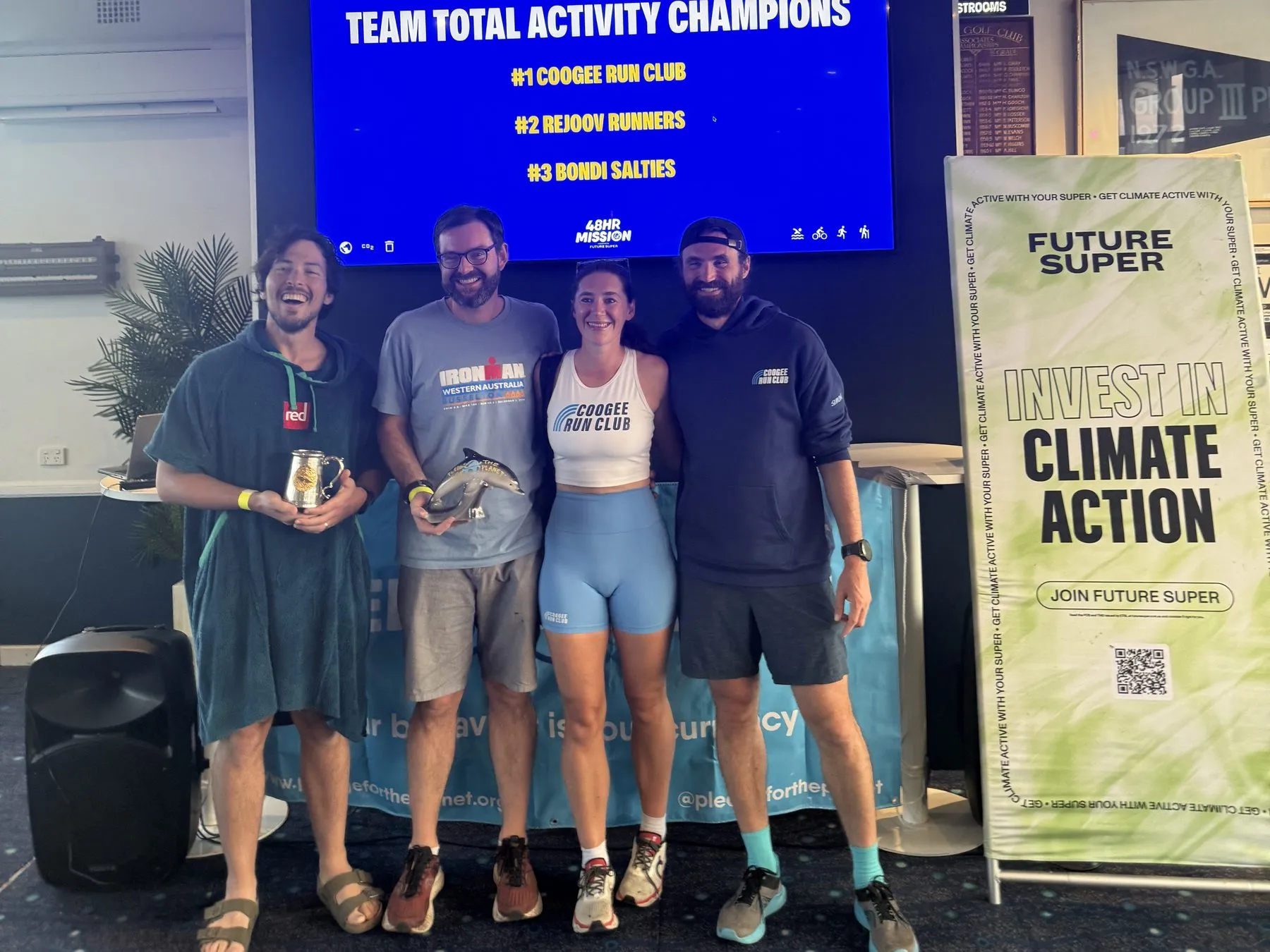 Coogee Run Club and Rejoov Runners members with their trophies beside a Future Super banner at the 48 Hour Mission 2025 awards