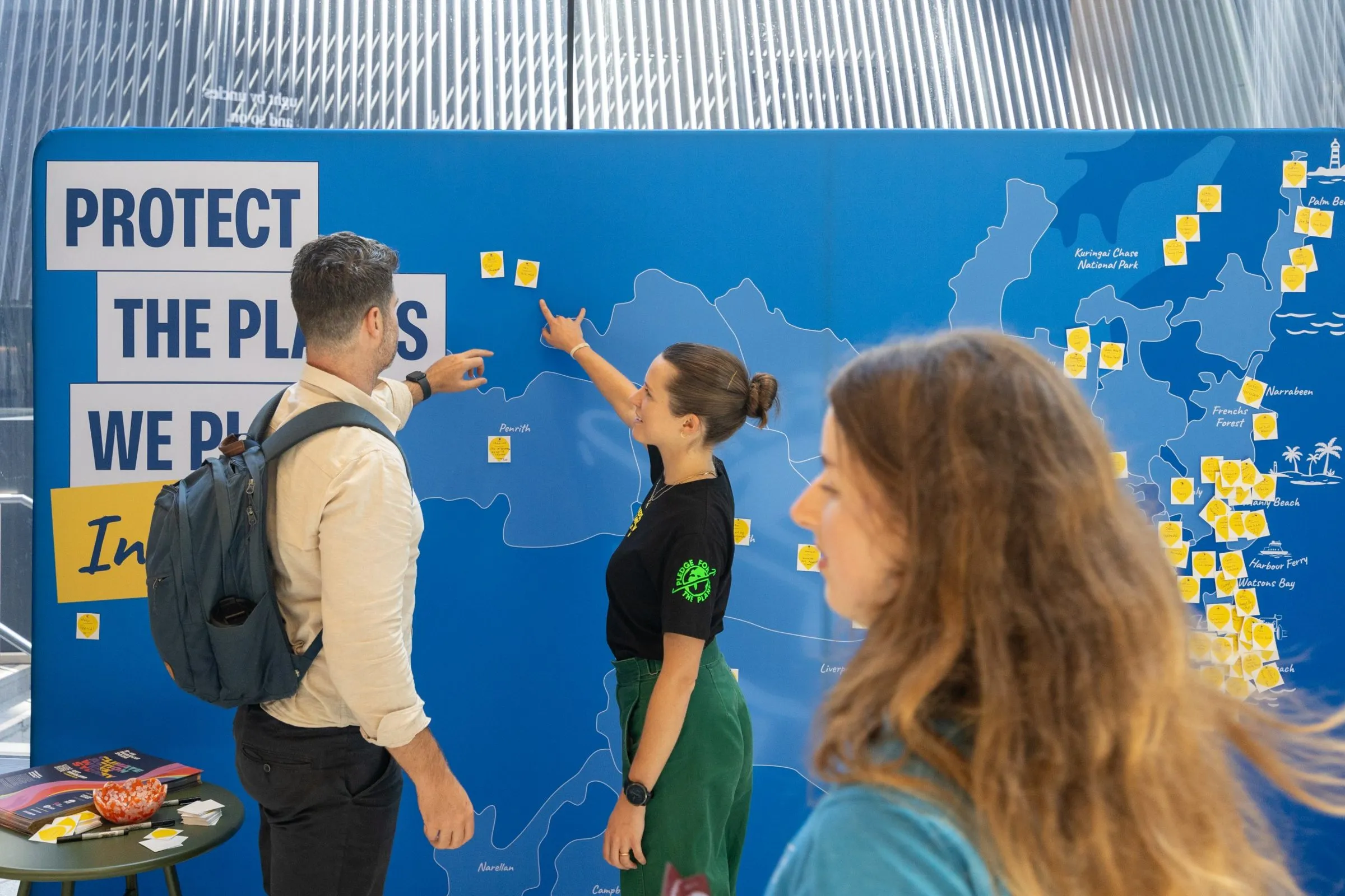 Colleagues adding pledges to a workplace pledge wall