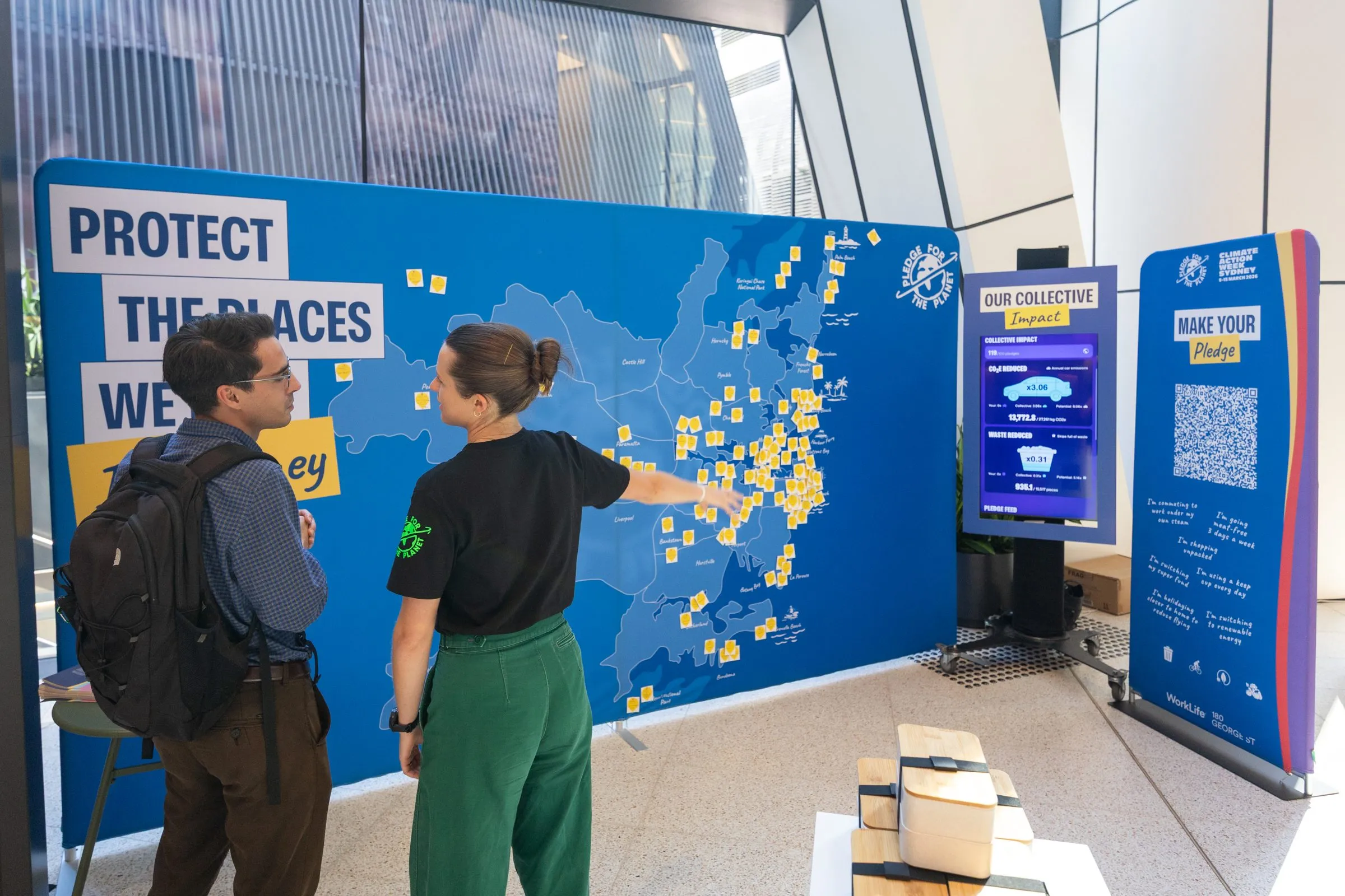 A workplace lobby activation with staff adding pledges to a wall