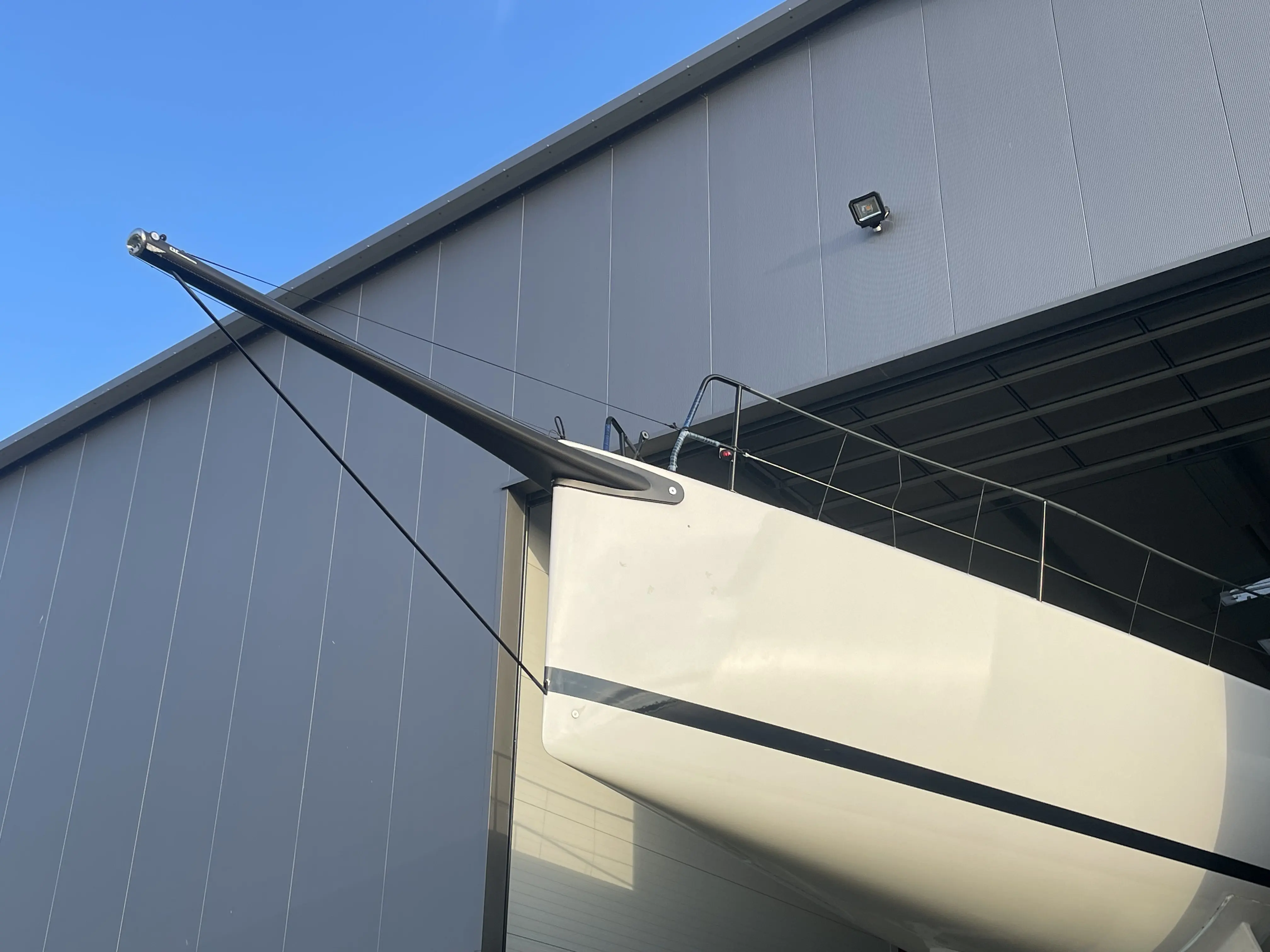 Bug einer Segelyacht vor einer großen Lagerhalle in Greifswald-Ladebow.