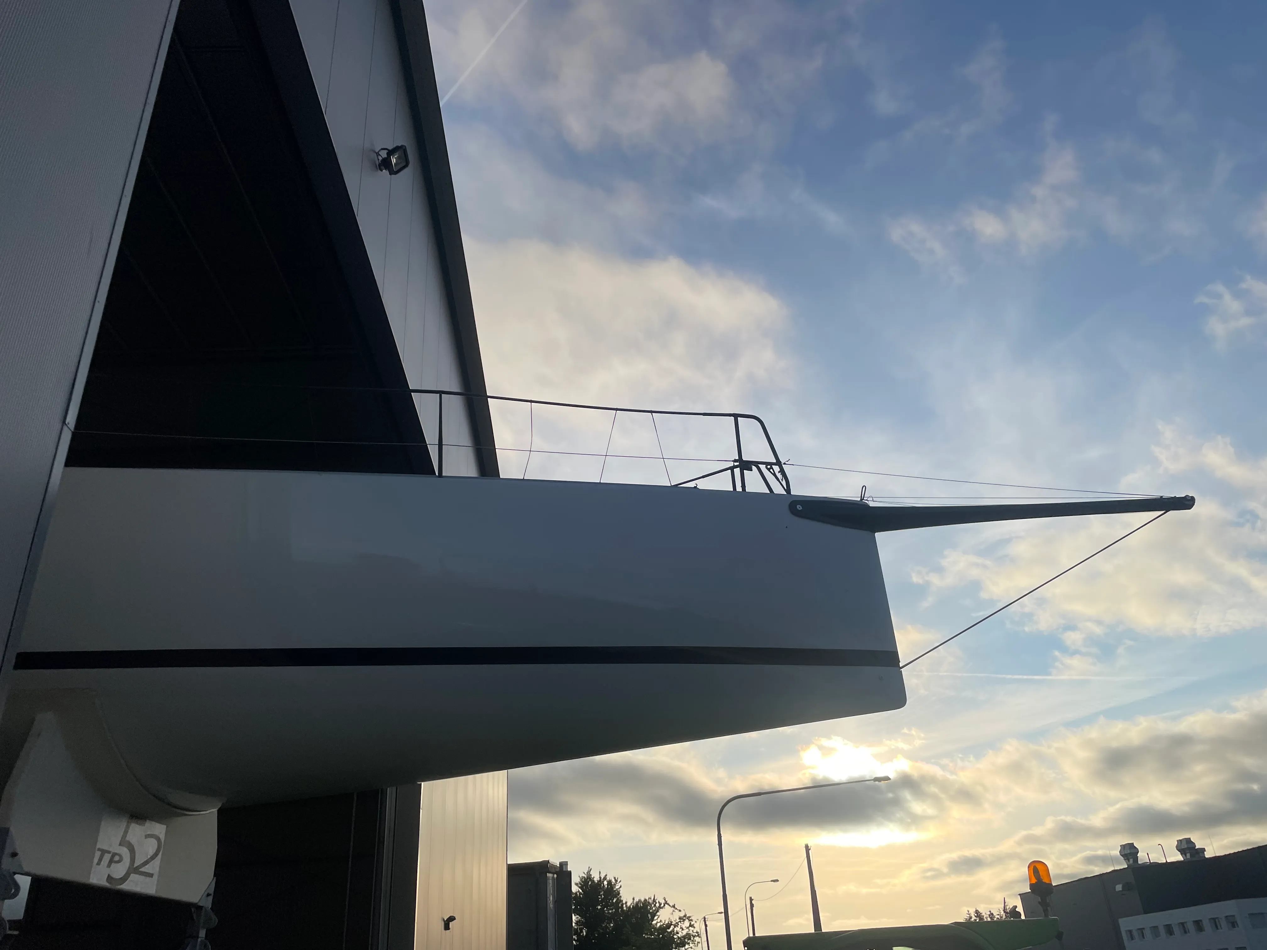 Bug einer Segelyacht neben der Lagerhalle bei Sonnenuntergang.