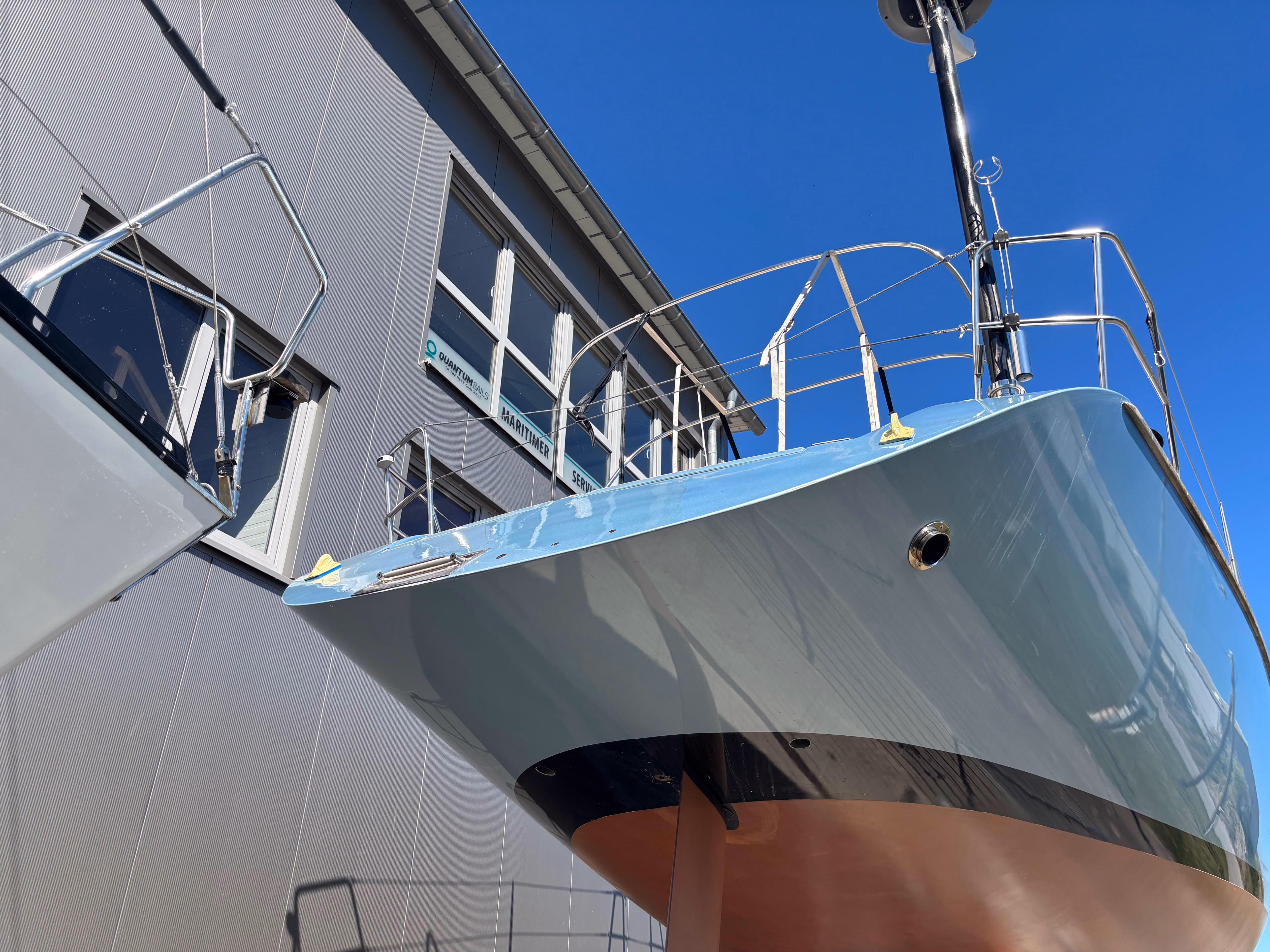 Mehrere Boote stehen im Trockendock am Hafen bei bewölktem Himmel.