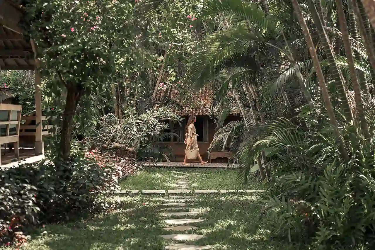 Picturesque tropical jimbaran view while walking through lush tropical garden toward traditional villa at Balquisse Heritage Hotel, a serene boutique retreat in Jimbaran, Bali