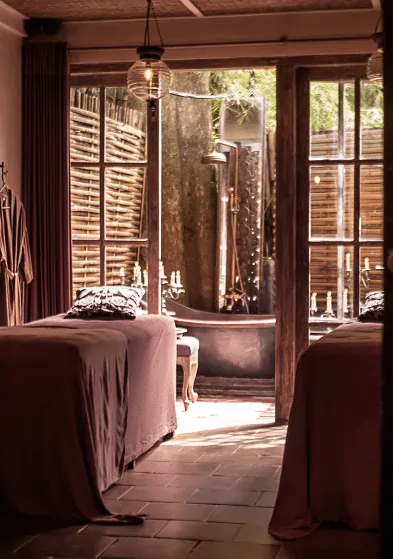 Elegant spa room with twin massage beds and outdoor tub at Balquisse Heritage Hotel, ideal for healing and wellness retreat in Jimbaran.