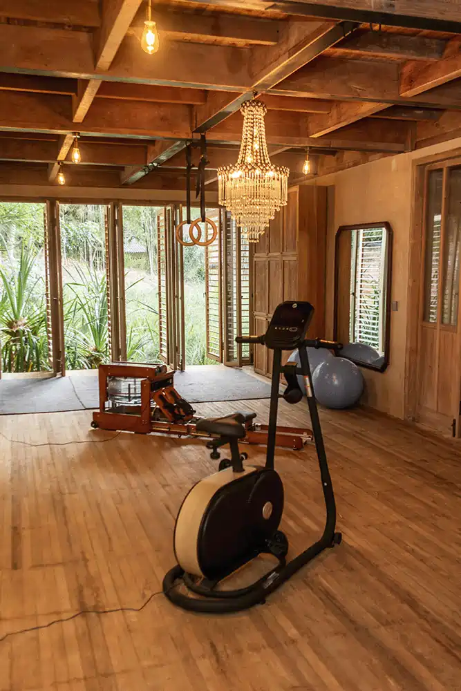 Elegant gym space with chandelier and exercise equipment at Balquisse Heritage Hotel Bali, part of a healing and wellness retreat in Jimbaran.