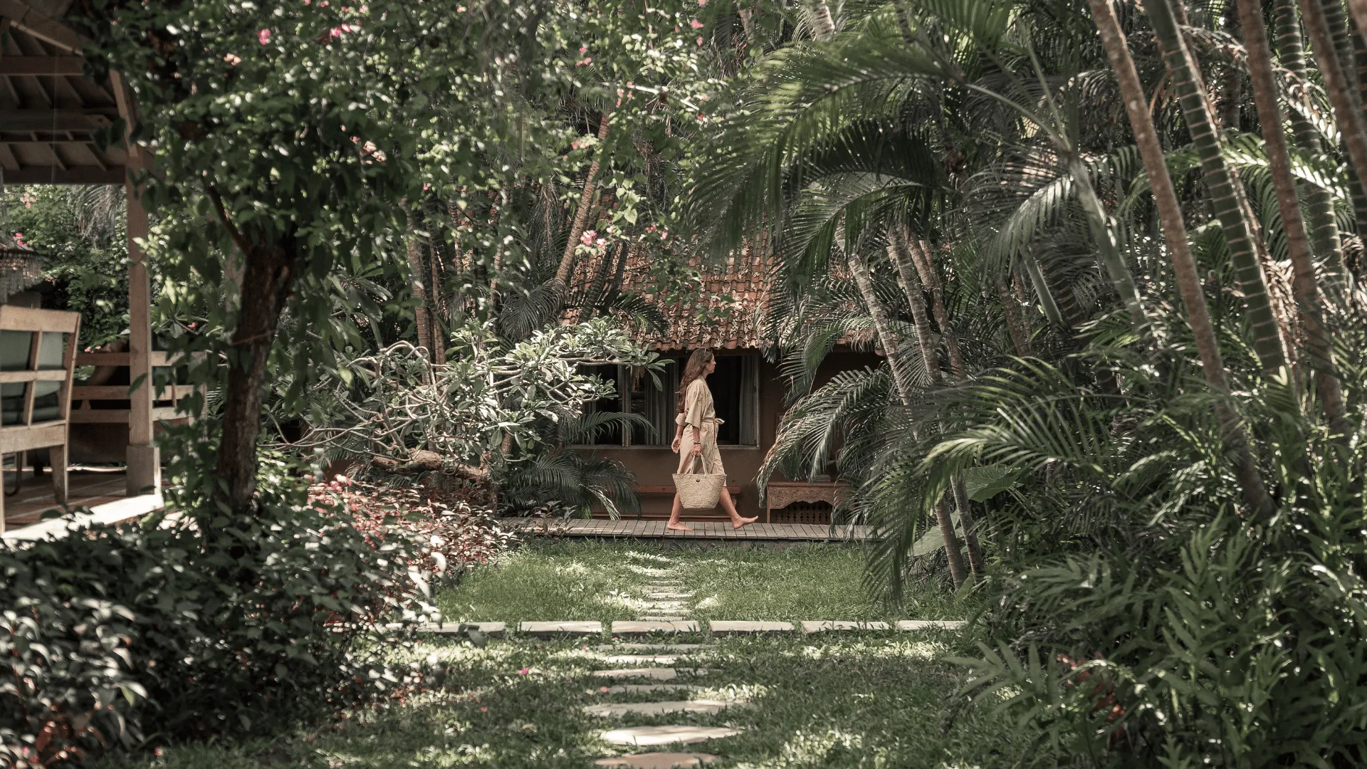 Balquisse Heritage Hotel tropical garden pathway with guest, showcasing the property's boutique hotel style in Bali