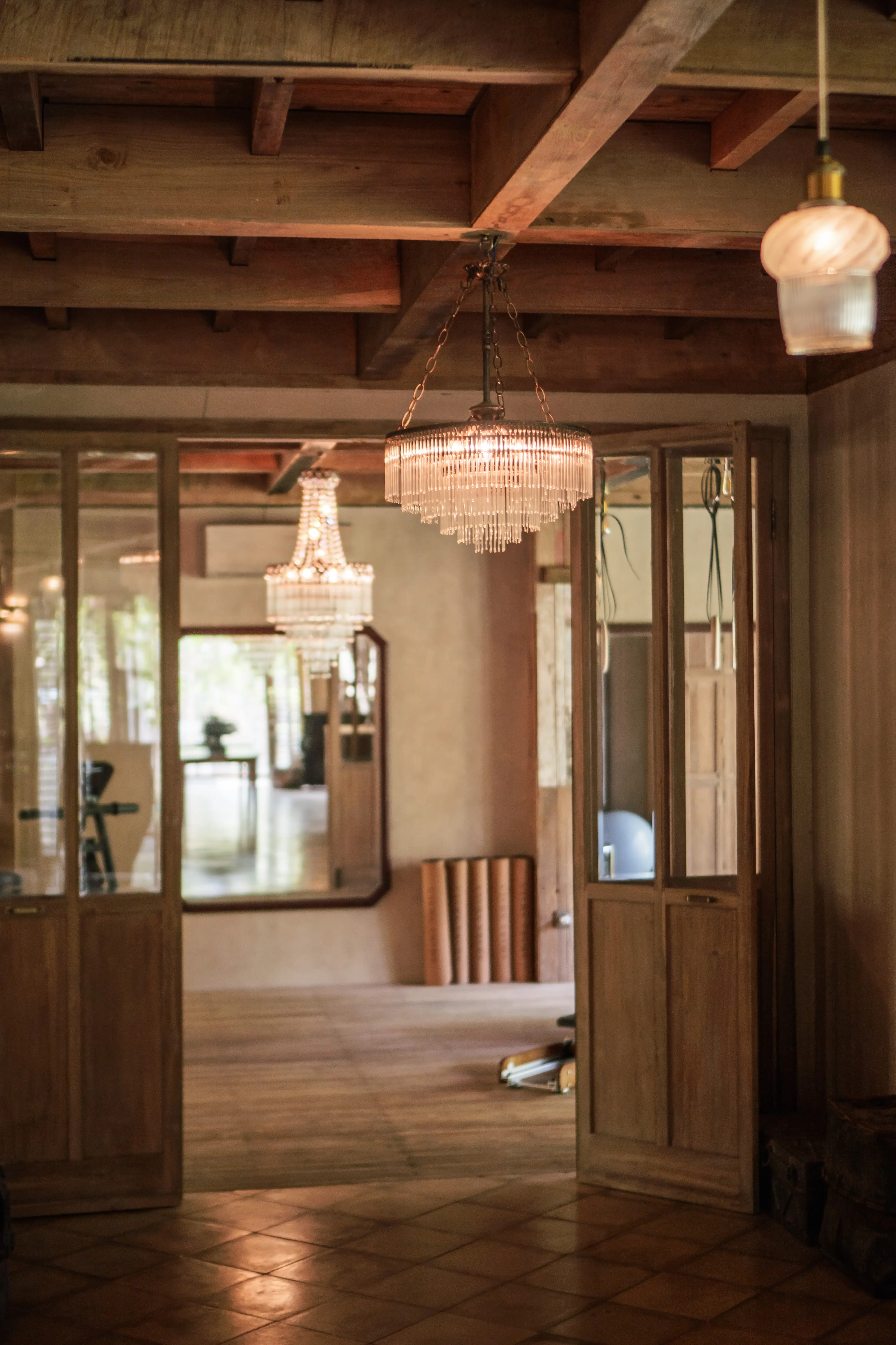 Elegant boutique gym interior with wooden doors and crystal chandeliers at Balquisse Heritage Hotel, Jimbaran, Bali.
