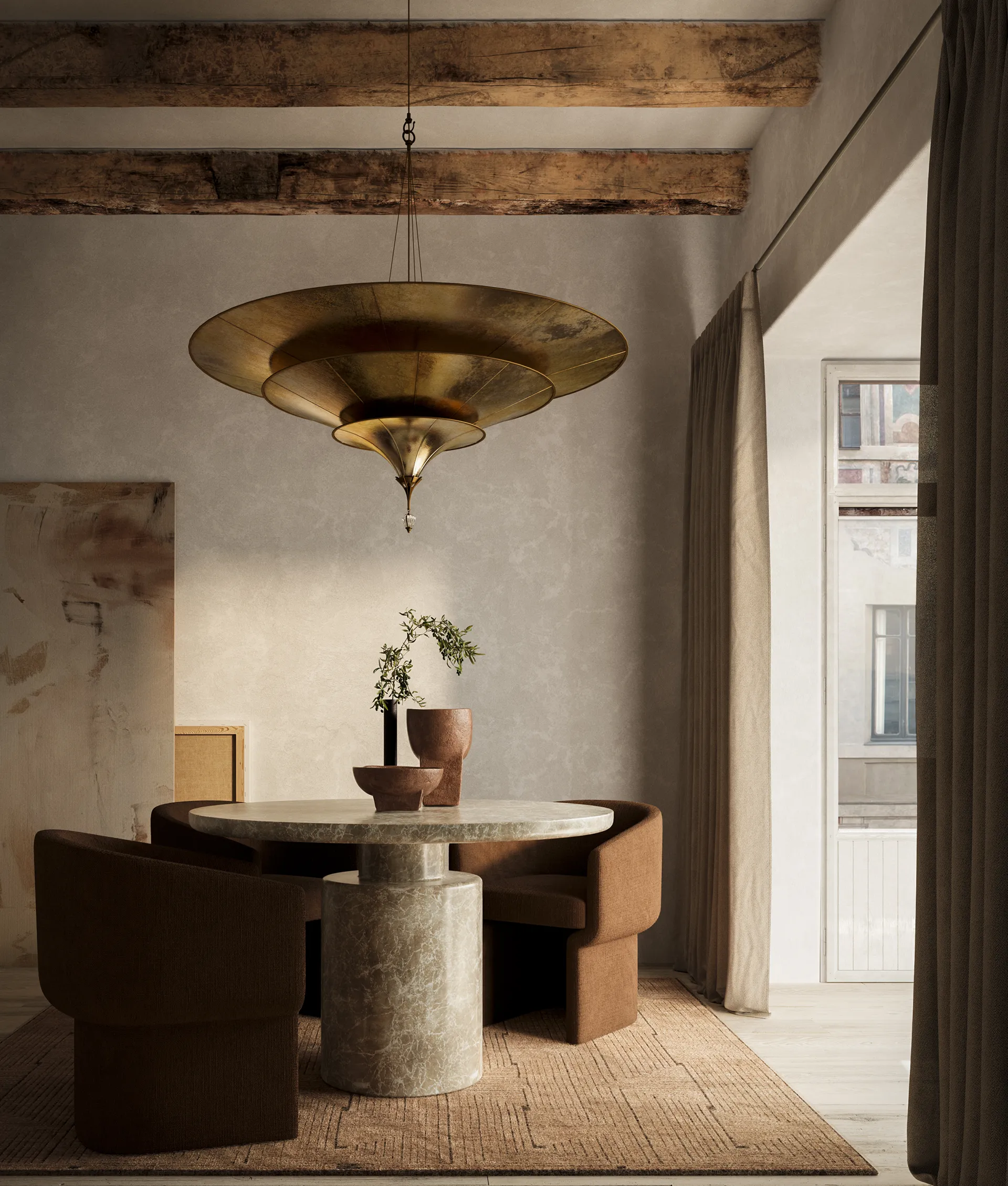 Dining room with round stone table, brown chairs, and large brass pendant light.