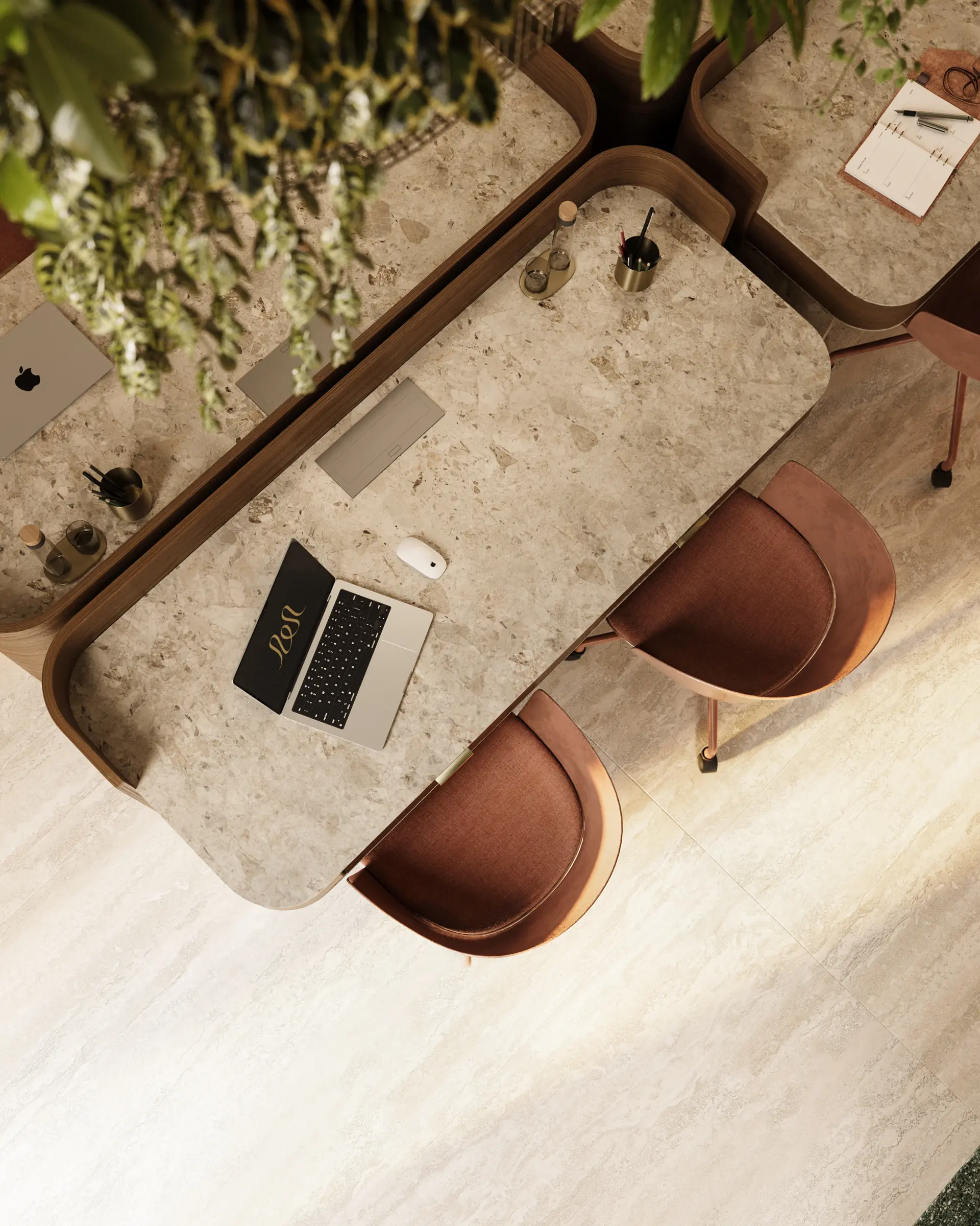 Top-down view of a modern workspace with a marble desk, brown chairs, laptop, and office supplies under hanging greenery.