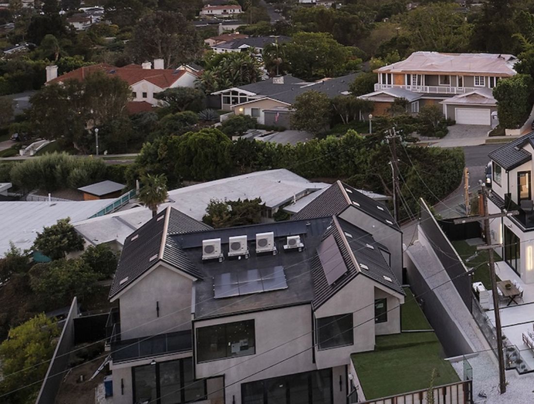 Aerial revealing four rooftop Daikin Fit heat pumps beside solar panels — Rhino Air installation