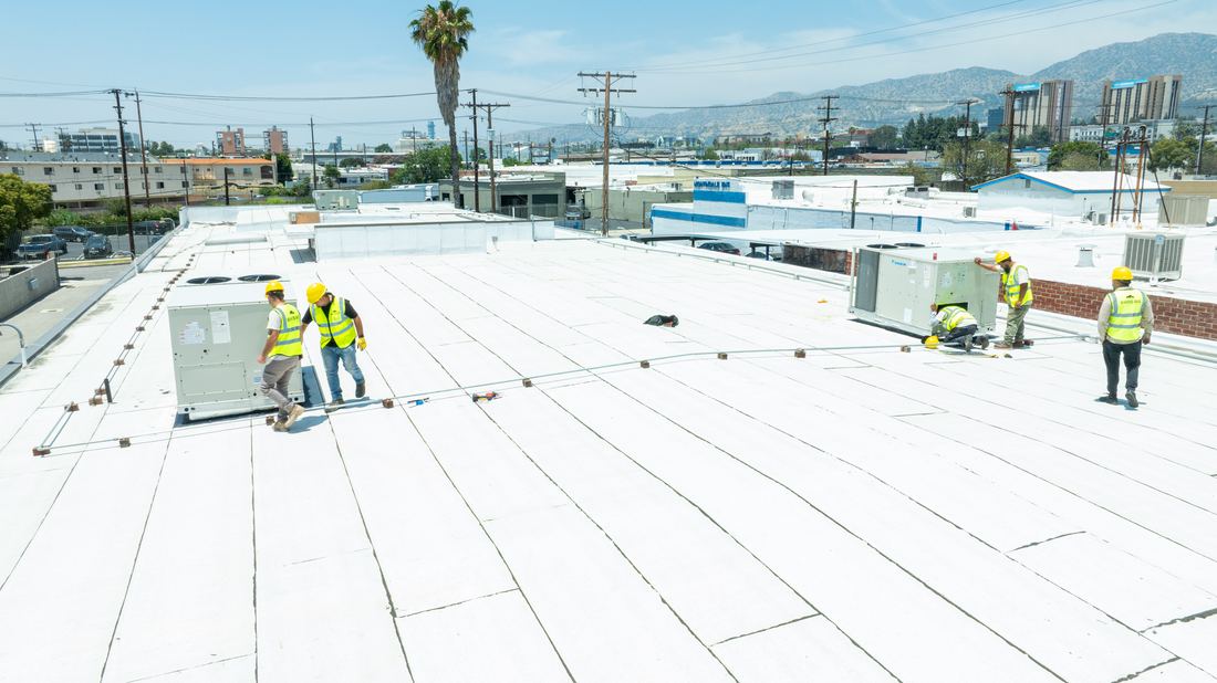 Rhino Air crews installing rooftop HVAC units on a Burbank media data center, Burbank hills in the background