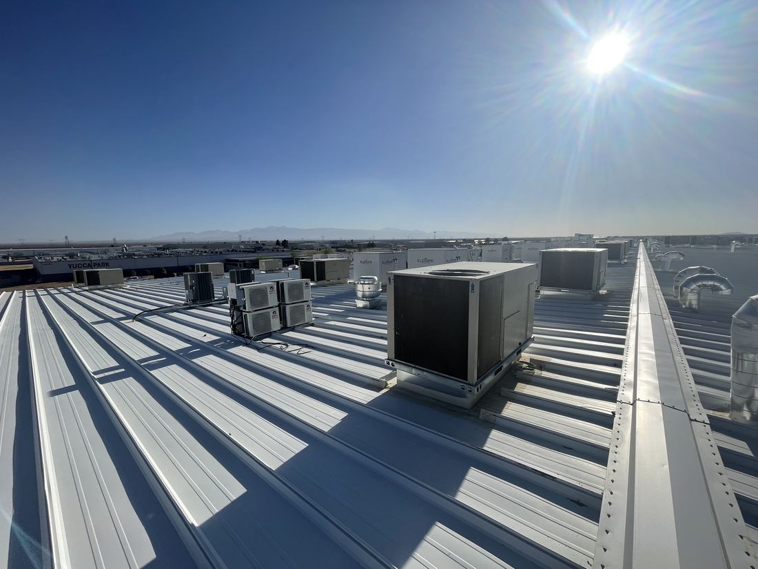 Rooftop HVAC equipment field on a large commercial manufacturing facility — package units and mini-split systems installed by Rhino Air