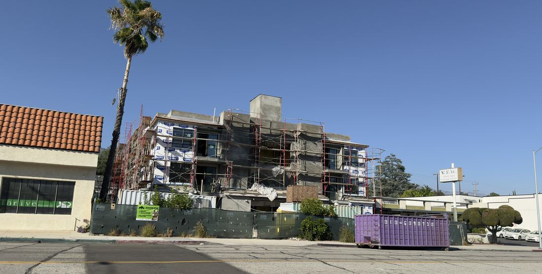 Glendale multifamily jobsite with Rhino Air banner on the construction fence — HVAC scope in progress