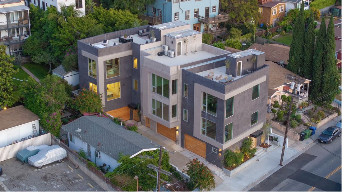 Completed three-building multifamily development in East Hollywood at dusk — rooftop mini-split systems by Rhino Air
