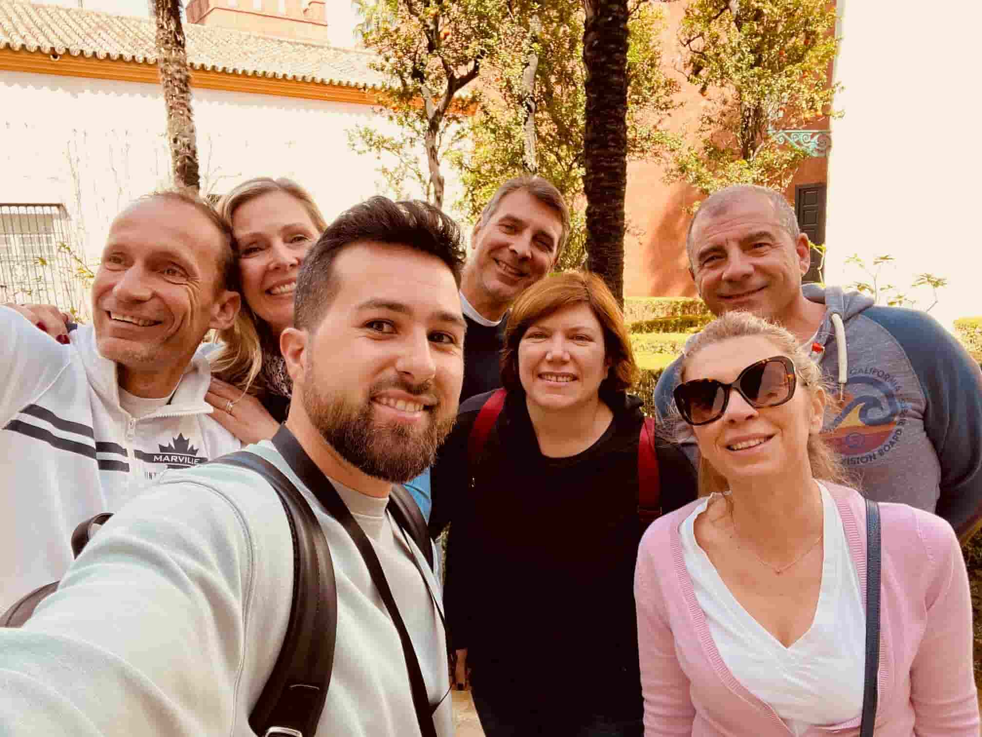 Samuel durante una visita guidata al Real Alcázar di Siviglia con un gruppo di visitatori sorridenti
